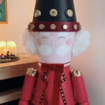 Détail du visage et du chapeau du casse-noisette géant fait maison, décoration de Noël artisanale.