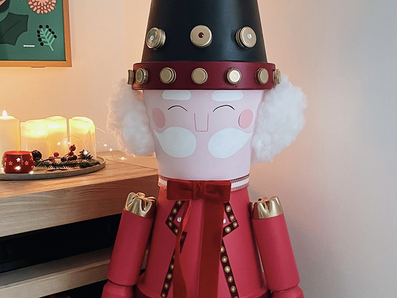 Détail du visage et du chapeau du casse-noisette géant fait maison, décoration de Noël artisanale.