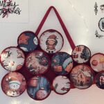 DIY déco murale de Noël accrochée au mur avec des images festives dans des couvercles recyclés