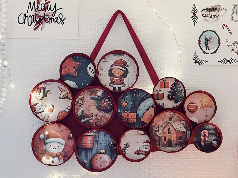 DIY déco murale de Noël accrochée au mur avec des images festives dans des couvercles recyclés